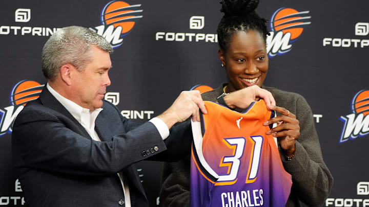 Feb 10, 2022; Phoenix, Arizona, USA; Phoenix Mercury general manager Jim Pitman (left) and Tina Charles hold up her jersey during Charles introductory press conference at Footprint Center. Mandatory Credit: Patrick Breen-The Republic 