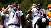 Cincinnati Bengals defensive end Jackson Carman (79) and Cincinnati Bengals offensive tackle D'Ante Smith (70) drink water while practicing in 91 degree weather at the Cincinnati Bengals NFL training camp practice in Cincinnati on Thursday, Aug. 3, 2023.