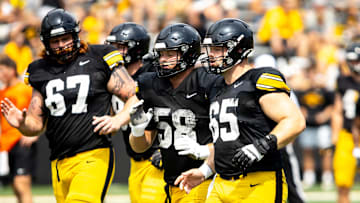 Aug 9, 2025; Iowa offensive linemen Gennings Dunker (67) Kade Pieper (58) and Logan Jones (65) run a drill during the Hawkeyes Kids Day NCAA football open practice at Kinnick Stadium in Iowa City, Iowa. Mandatory Credit: Joseph Cress for the Des Moines Register