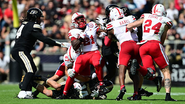 Sep 28, 2024; West Lafayette, Indiana, USA; Nebraska Cornhuskers running back Emmett Johnson (21) is tackled by Purdue Boilermakers linebacker Yanni Karlaftis (14) during the second half at Ross-Ade Stadium. Sep 28, 2024; West Lafayette, Indiana, USA; Nebraska Cornhuskers running back Emmett Johnson (21) is tackled by Purdue Boilermakers linebacker Yanni Karlaftis (14) during the second half at Ross-Ade Stadium.