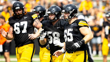 Aug 9, 2025; Iowa offensive linemen Gennings Dunker (67) Kade Pieper (58) and Logan Jones (65) run a drill during the Hawkeyes Kids Day NCAA football open practice at Kinnick Stadium in Iowa City, Iowa. Mandatory Credit: Joseph Cress for the Des Moines Register