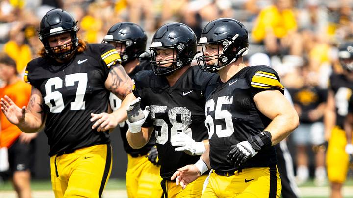 Aug 9, 2025; Iowa offensive linemen Gennings Dunker (67) Kade Pieper (58) and Logan Jones (65) run a drill during the Hawkeyes Kids Day NCAA football open practice at Kinnick Stadium in Iowa City, Iowa. Mandatory Credit: Joseph Cress for the Des Moines Register