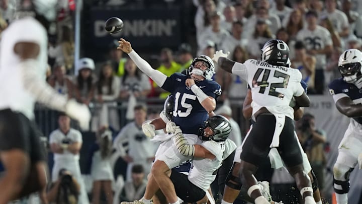 Penn State Nittany Lions quarterback Drew Allar (15) is tackled by Oregon Ducks linebackers Kamar Mothudi (33) and Teitum Tuioti (44) during the second quarter at Beaver Stadium.