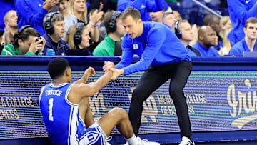 Duke v Notre Dame; Duke basketball head coach Jon Scheyer helps up guard Caleb Foster 