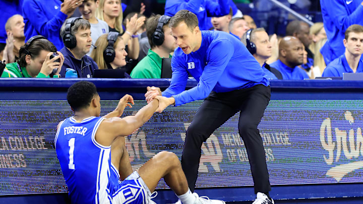Duke v Notre Dame; Duke basketball head coach Jon Scheyer helps up guard Caleb Foster 