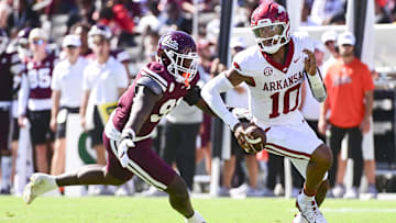 Oct 26, 2024; Starkville, Mississippi, USA; Arkansas Razorbacks quarterback Taylen Green (10) runs the ball while defended by Mississippi State Bulldogs defensive lineman Deonte Anderson (91) during the second quarter at Davis Wade Stadium at Scott Field. Mandatory Credit: Matt Bush-Imagn Images