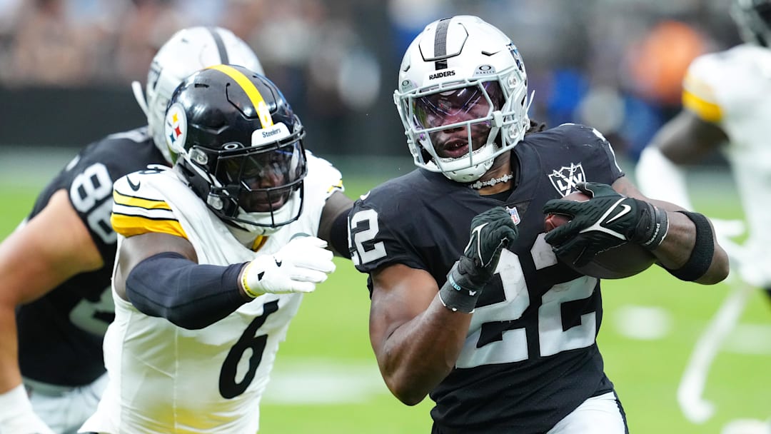 Oct 13, 2024; Paradise, Nevada, USA; Las Vegas Raiders running back Alexander Mattison (22) looks to evade the tackle attempt of Pittsburgh Steelers linebacker Patrick Queen (6) during the first quarter at Allegiant Stadium. Mandatory Credit: Stephen R. Sylvanie-Imagn Images