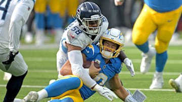Nov 10, 2024; Inglewood, California, USA;  Los Angeles Chargers quarterback Justin Herbert (10) is stopped by Tennessee Titans linebacker Harold Landry III (58) after a first down in the first half at SoFi Stadium. 