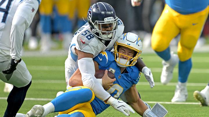 Nov 10, 2024; Inglewood, California, USA;  Los Angeles Chargers quarterback Justin Herbert (10) is stopped by Tennessee Titans linebacker Harold Landry III (58) after a first down in the first half at SoFi Stadium. 