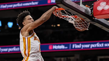 Atlanta Hawks forward Jalen Johnson puts his head above the rim while dunking the ball against the Detroit Pistons