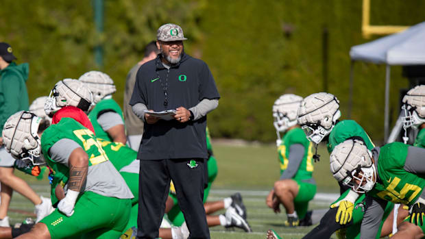 Oregon offensive line coach Tony Tuioti walks the field during practice with the Oregon Ducks