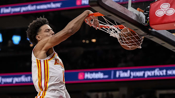 Atlanta Hawks forward Jalen Johnson puts his head above the rim while dunking the ball against the Detroit Pistons