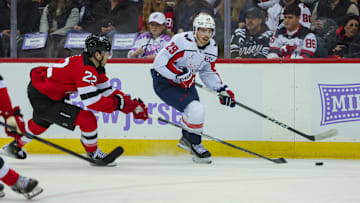 Nov 30, 2024; Newark, New Jersey, USA; Washington Capitals center Hendrix Lapierre (29) moves the puck while New Jersey Devils defenseman Brett Pesce (22) defends during the first period at Prudential Center. Mandatory Credit: Thomas Salus-Imagn Images