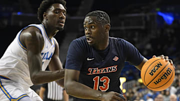 Nov 22, 2024; Los Angeles, California, USA; Cal State Fullerton Titans guard Kaleb Brown (13) drives to the basket past UCLA Bruins guard Eric Dailey Jr. (3) during the first half at Pauley Pavilion presented by Wescom. Mandatory Credit: Robert Hanashiro-Imagn Images
