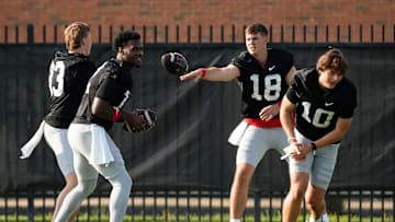 Aug 1, 2024; Columbus, OH, USA; Ohio State Buckeyes quarterbacks, from left, Devin Brown (33), Air Noland (12), Will Howard (18) and Julian Sayin (10) work on a drill during football camp at the Woody Hayes Athletic Complex.