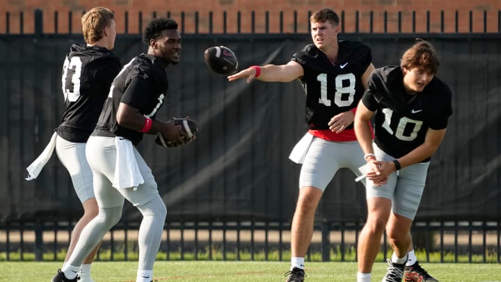 Aug 1, 2024; Columbus, OH, USA; Ohio State Buckeyes quarterbacks, from left, Devin Brown (33), Air Noland (12), Will Howard (18) and Julian Sayin (10) work on a drill during football camp at the Woody Hayes Athletic Complex.