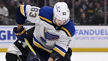 Mar 5, 2025; Los Angeles, California, USA;  St. Louis Blues left wing Jake Neighbours (63) controls the puck against Los Angeles Kings defenseman Mikey Anderson (44) during the third period at Crypto.com Arena. Mandatory Credit: Alex Gallardo-Imagn Images