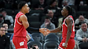 Dec 14, 2024; Indianapolis, Indiana, USA;  Wisconsin Badgers guard John Tonje (9) and guard John Blackwell (25) react after a play during the first half against the Butler Bulldogs at Gainbridge Fieldhouse.