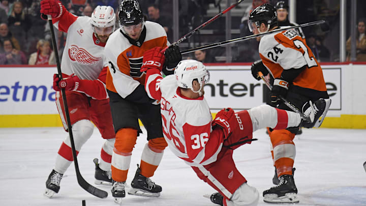 Jan 21, 2025; Philadelphia, Pennsylvania, USA; Detroit Red Wings center Michael Rasmussen (27) and Philadelphia Flyers defenseman Jamie Drysdale (9) battle for the puck with right wing Christian Fischer (36) during the second period at Wells Fargo Center.