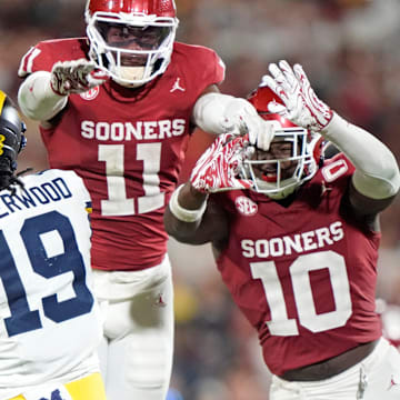 Oklahoma's Kobie McKinzie (11) and Kip Lewis (10) pressure Michigan's Bryce Underwood