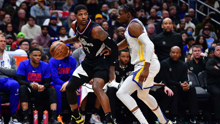 Mar 15, 2023; Los Angeles, California, USA; Los Angeles Clippers forward Paul George (13) moves the ball against Golden State Warriors forward Jonathan Kuminga (00) during the second half at Crypto.com Arena. Mandatory Credit: Gary A. Vasquez-USA TODAY Sports