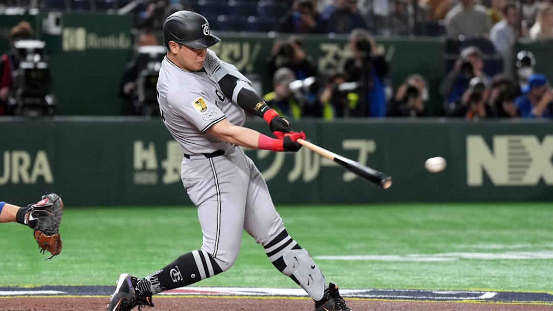 Mar 16, 2025; Bunkyo, Tokyo, Japan; Yomiuri Giants first baseman Kazuma Okamoto (25) hits a single against the Chicago Cubs during the second inning at Tokyo Dome. Mandatory Credit: Darren Yamashita-Imagn Images