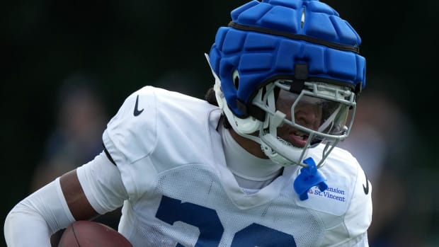 Colts cornerback Jaylin Simpson (white jersey with blue helmet cap) runs with the football during training camp practice. 