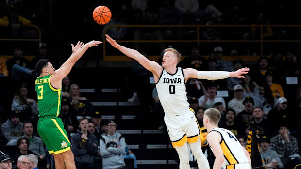 Iowa forward Even Brauns (0) defends a 3 attempted by Oregon guard Jackson Shelstad (3)