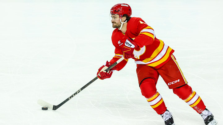 Apr 13, 2025; Calgary, Alberta, CAN; Calgary Flames defenseman Rasmus Andersson (4) skates with the puck against the San Jose Sharks during the first period at Scotiabank Saddledome. Mandatory Credit: Sergei Belski-Imagn Images