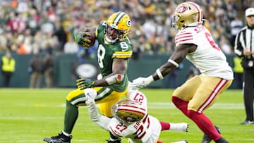 Nov 24, 2024; Green Bay, Wisconsin, USA;  Green Bay Packers running back Josh Jacobs (8) is tackled by San Francisco 49ers safety Ji'Ayir Brown (27) during the first quarter at Lambeau Field.