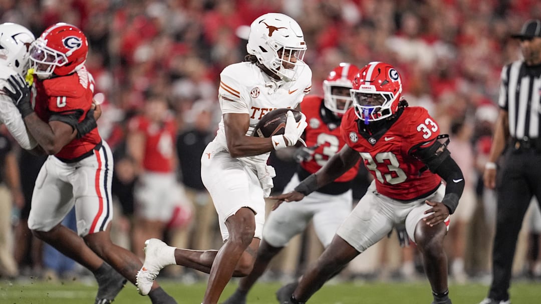 Texas Longhorns wide receiver Ryan Wingo runs with the ball while pursued by Georgia Bulldogs linebacker Quintavius Johnson in the first half at Sanford Stadium.