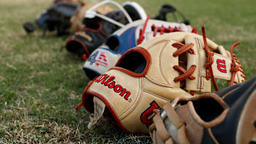 Players gloves before the start of a high school softball game.