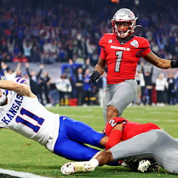 Dec 26, 2023; Phoenix, AZ, USA; Kansas Jayhawks wide receiver Luke Grimm (11) scores a touchdown against UNLV Rebels defensive back Jaxen Turner (2) during the second half in the Guaranteed Rate Bowl at Chase Field.