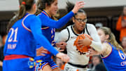 Oklahoma State Cowgirls guard Stailee Heard (32) goes to tthe basket between Kansas Jayhawks forward Regan Williams (24) and Kansas Jayhawks guard Laia Conesa (6) during a women's BIG 12 basketball game between the Oklahoma State University Cowgirls (OSU) and the Kansas Jayhawks at Gallagher-Iba Arena in Stillwater, Okla., Saturday, Jan. 4, 2025.