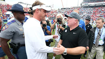 Sep 28, 2024; Oxford, Mississippi, USA; Mississippi Rebels head coach Lane Kiffin (left) and Kentucky Wildcats head coach Mark Stoops (right) shake hands after the game at Vaught-Hemingway Stadium. Mandatory Credit: Petre Thomas-Imagn Images