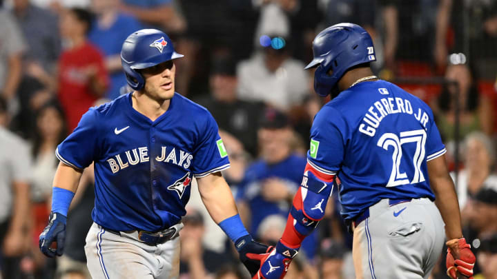 Toronto Blue Jays center fielder Daulton Varsho (25) high-fives first baseman Vladimir Guerrero Jr. (27) after hitting a home run against the Boston Red Sox during the ninth inning at Fenway Park on Aug 27.