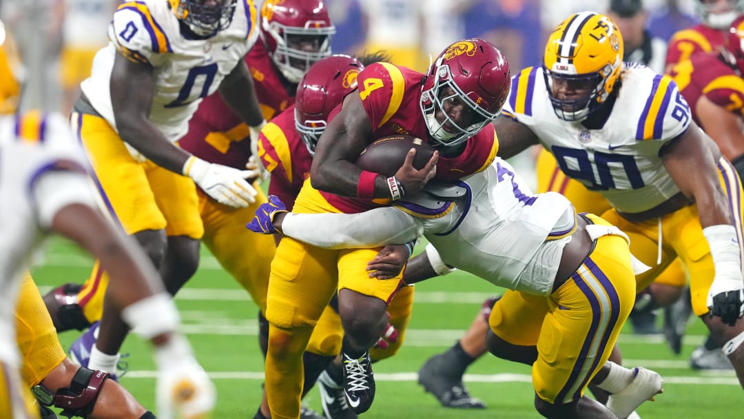 Sep 1, 2024; Paradise, Nevada, USA; Southern California Trojans running back Woody Marks (4) is tackled by LSU Tigers linebacker Harold Perkins Jr. (7) during the second quarter at Allegiant Stadium.