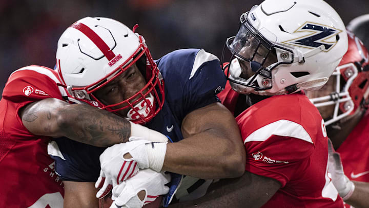 West running back Devine Ozigbo of Nebraska runs the ball as East cornerback Derrick Baity Jr of Kentucky and linebacker Ulysees Gilbert III of Akron defend. West running back Devine Ozigbo of Nebraska runs the ball as East cornerback Derrick Baity Jr of Kentucky and linebacker Ulysees Gilbert III of Akron defend.