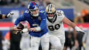 Dec 8, 2024; East Rutherford, New Jersey, USA; New York Giants quarterback Drew Lock (2) runs with the ball against New Orleans Saints defensive end Carl Granderson (96) and defensive tackle Bryan Bresee (90) during the fourth quarter at MetLife Stadium. Mandatory Credit: Brad Penner-Imagn Images