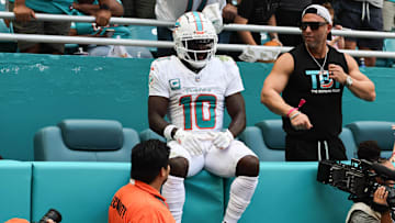Oct 27, 2024; Miami Gardens, Florida, USA; Miami Dolphins wide receiver Tyreek Hill (10) sits on the stands after running out of bounds against the Arizona Cardinals during the second quarter at Hard Rock Stadium.