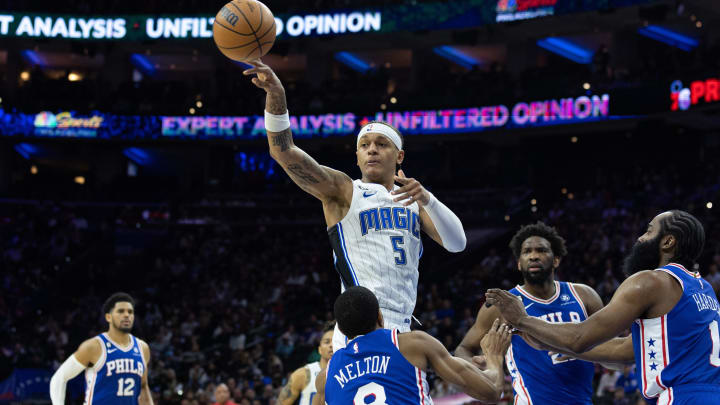 Feb 1, 2023; Philadelphia, Pennsylvania, USA; Orlando Magic forward Paolo Banchero (5) passes the ball past Philadelphia 76ers guard De'Anthony Melton (8) and guard James Harden (1) during the second quarter at Wells Fargo Center. Mandatory Credit: Bill Streicher-USA TODAY Sports