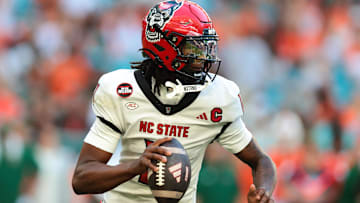Nov 15, 2025; Miami Gardens, Florida, USA; NC State Wolfpack quarterback CJ Bailey (11) looks for a passing option against the Miami Hurricanes during the second quarter at Hard Rock Stadium. Mandatory Credit: Sam Navarro-Imagn Images