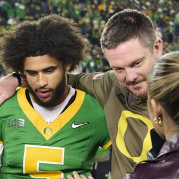 Nov 14, 2025; Eugene, Oregon, USA; Oregon Ducks quarterback Dante Moore (5) and head coach Dan Lanning talk to a reporter after a game against the Minnesota Golden Gophers at Autzen Stadium. Mandatory Credit: Troy Wayrynen-Imagn Images