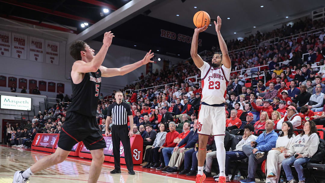 Dec 23, 2025; Queens, New York, USA;  St. John's basketball forward Bryce Hopkins (23) takes a three point shot past Harvard Crimson guard Ben Eisendrath (5) in the second half at Carnesecca Arena.