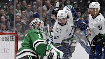 Apr 8, 2025; Dallas, Texas, USA; Vancouver Canucks defenseman Victor Mancini (90) crashes into Dallas Stars goaltender Casey DeSmith (1) during the third period at the American Airlines Center. Mandatory Credit: Jerome Miron-Imagn Images