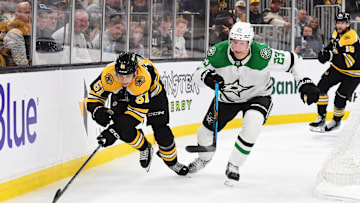 Oct 24, 2024; Boston, Massachusetts, USA;  Boston Bruins center Matthew Poitras (51) and Dallas Stars defenseman Esa Lindell (23) chase after the puck during the third period at TD Garden. Mandatory Credit: Bob DeChiara-Imagn Images