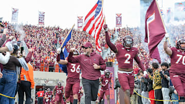 Nov 9, 2024; Blacksburg, Virginia, USA;  Virginia Tech Hokies head coach Brent Pry leads his team onto the filed with Virginia Tech Hokies wide receiver Takye Heath (2) before the game at Lane Stadium. Mandatory Credit: Brian Bishop-Imagn Images