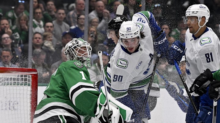 Apr 8, 2025; Dallas, Texas, USA; Vancouver Canucks defenseman Victor Mancini (90) crashes into Dallas Stars goaltender Casey DeSmith (1) during the third period at the American Airlines Center. Mandatory Credit: Jerome Miron-Imagn Images