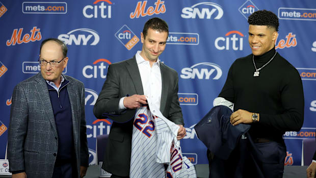 New York Mets president of baseball operations David Stearns hands Juan Soto his new jersey with owner Steve Cohen (left)