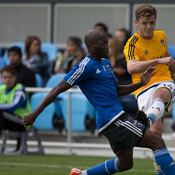 Feb 28, 2015; San Jose, CA, USA; Los Angeles Galaxy midfielder Robbie Rogers (14) kicks the ball against San Jose Earthquakes midfielder Sanna Nyassi (17) during the second half of the preseason game at Avaya Stadium. The San Jose Earthquakes defeated the Los Angeles Galaxy 3-2. Mandatory Credit: Kelley L Cox-Imagn Images